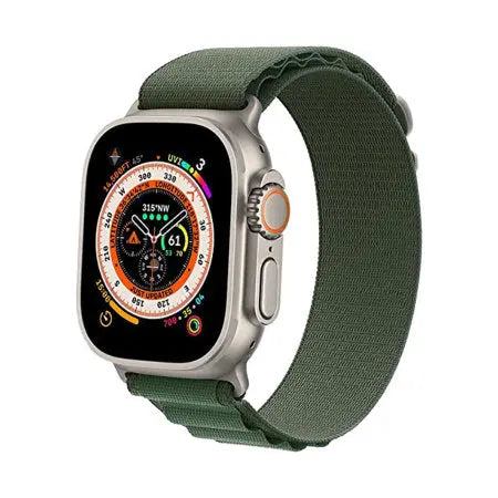 Apple Watch med grönt Alpine Loop-armband på en neutral bakgrund.