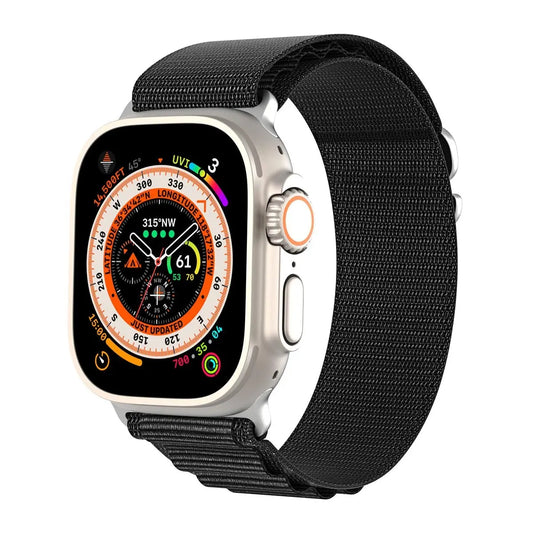 Apple Watch med svart Alpine Loop-armband i full fokus på urtavlan.