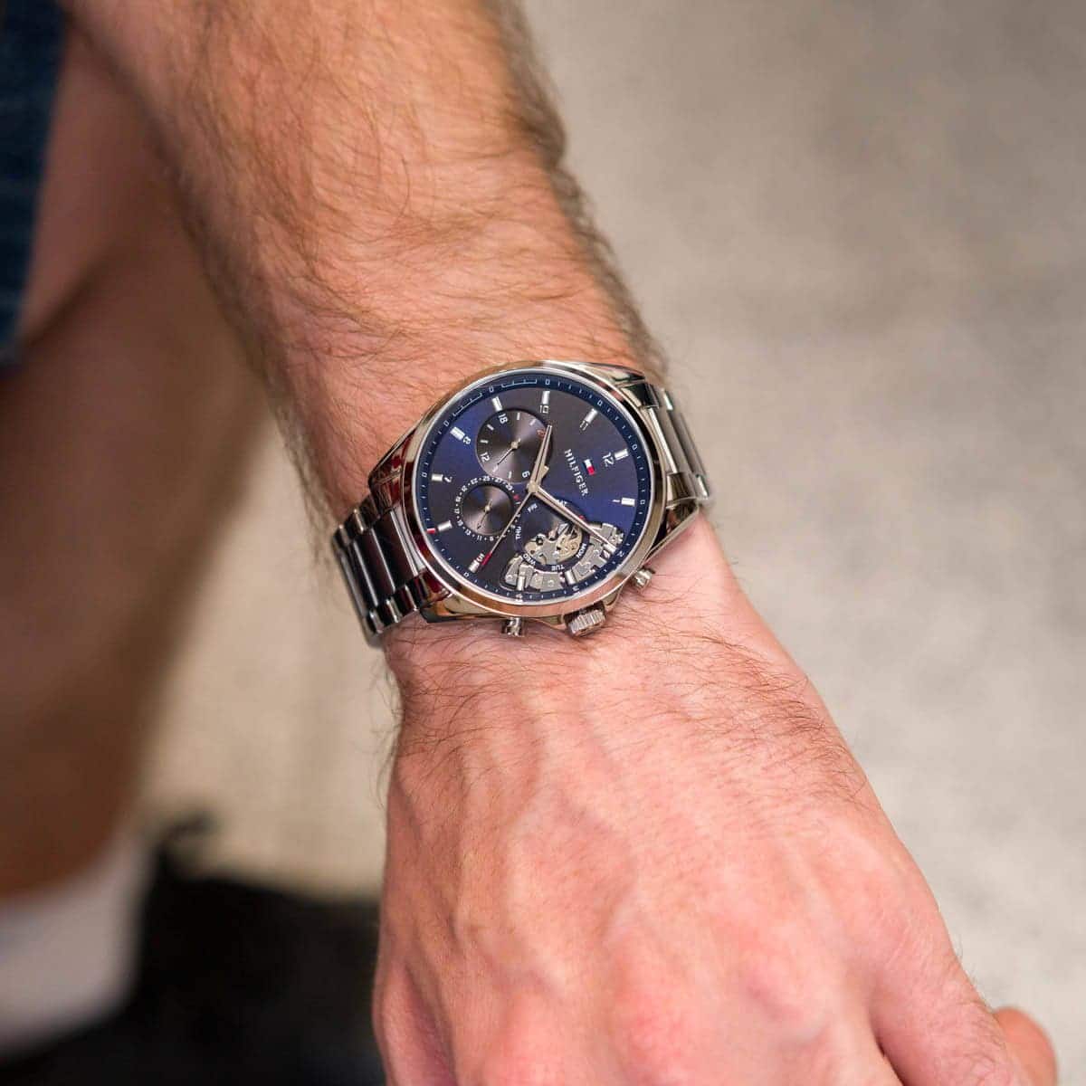 Tommy Hilfiger Baker 1710448 herrklocka med silverfärgat stålarmband och blå urtavla, visad framifrån.