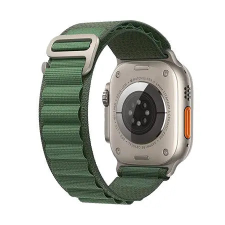 Apple Watch med grönt Alpine Loop-band som visar baksidan och spännet.