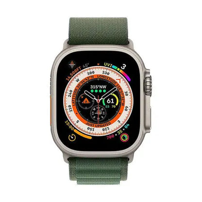 Grönt Alpine Loop-band på en Apple Watch med urtavla synlig.